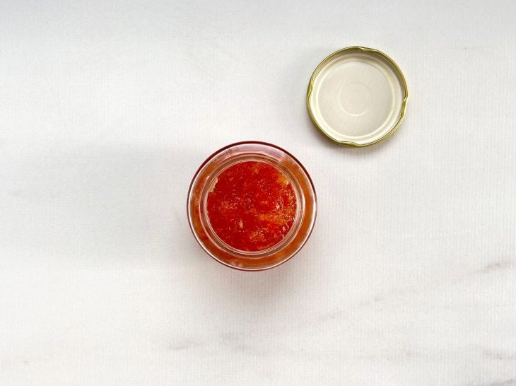 Um recipiente contendo geleia de pimenta.