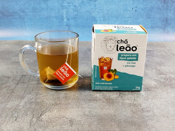 Sachê de chá em uma xícara de vidro com água.