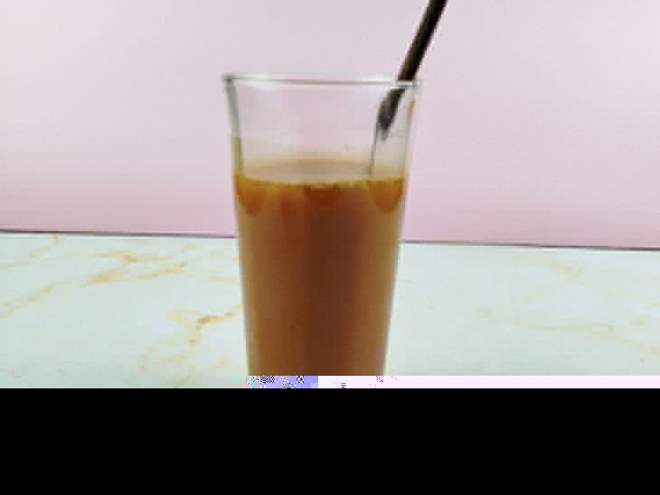 Um copo com a mistura de chá, suco de laranja, mel e guaraná.