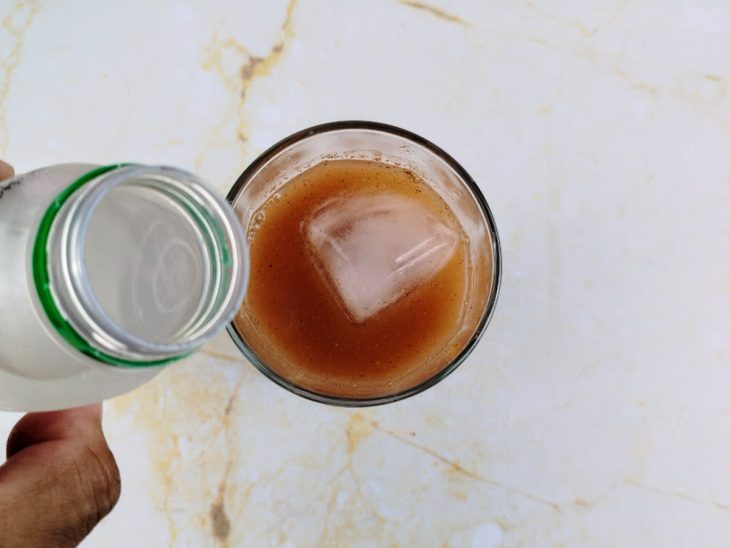 Água de coco sendo despejada no copo com os outros ingredientes.