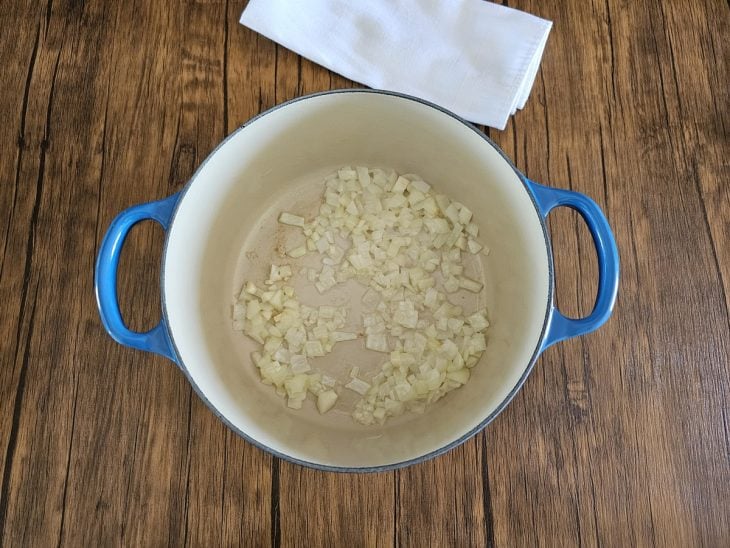 Panela com cebola sendo refogada.