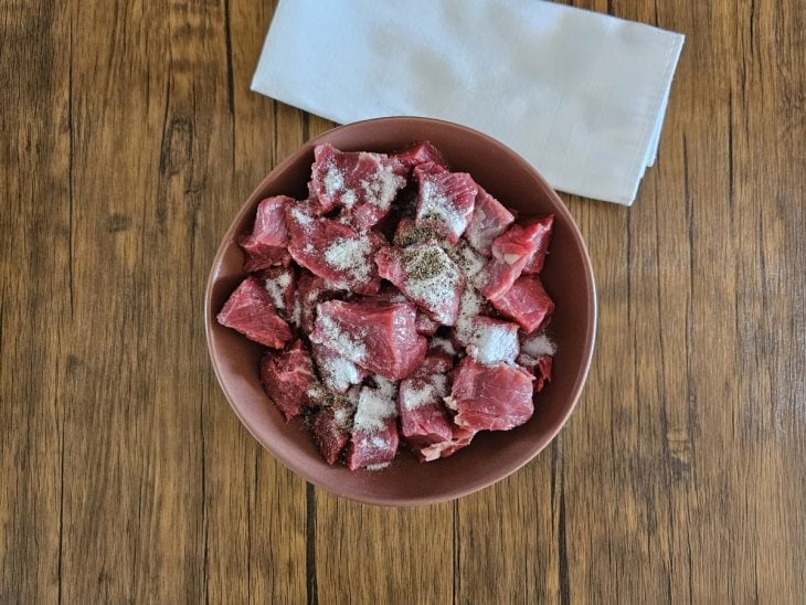 Recipiente com carne e temperos.