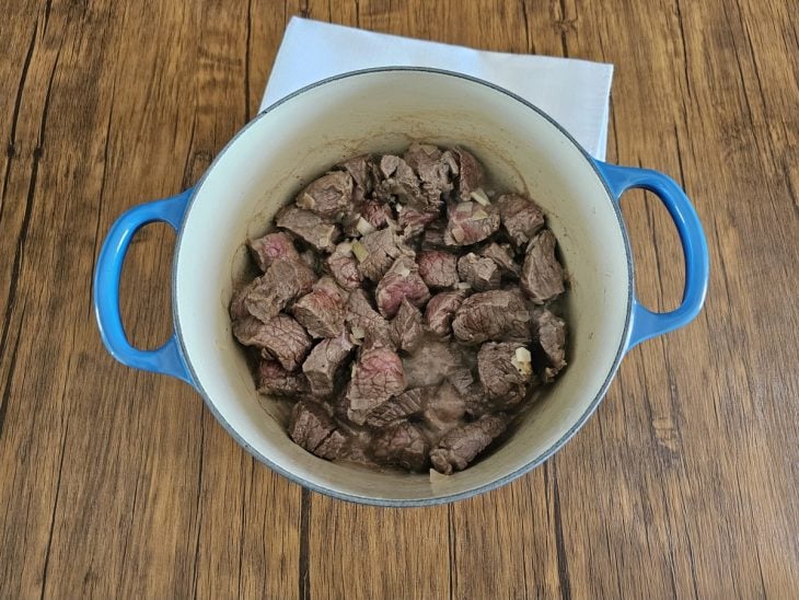 Panela com cubos de carne sendo refogados.