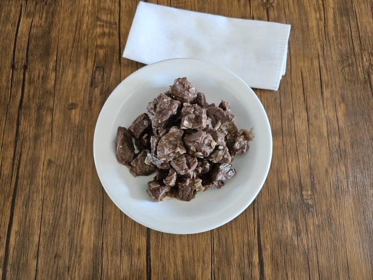 Cubos de carne refogados reservados em um prato.