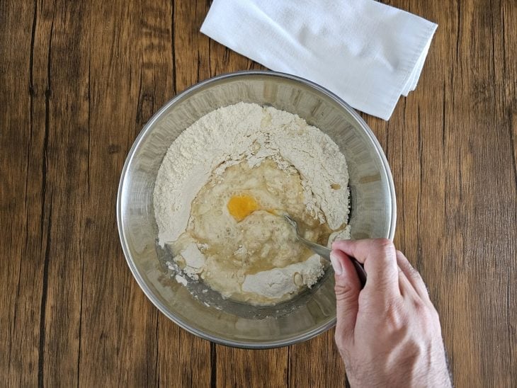 Ingredientes da massa sendo misturado com uma colher em uma tigela.