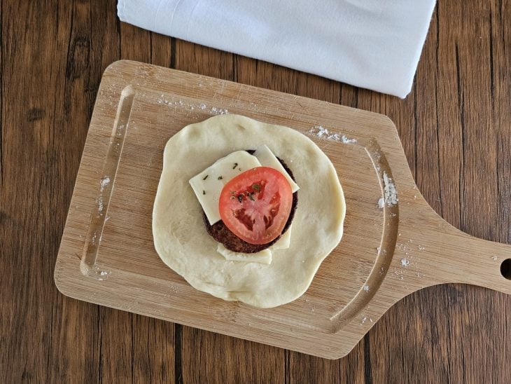 Bolinhas aberta e recheda com hambúrguer, queijo e tomate;