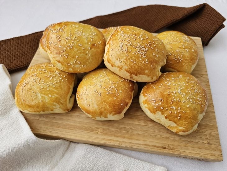 Hamburgão de forno assado e colocados em cima de uma tábua.