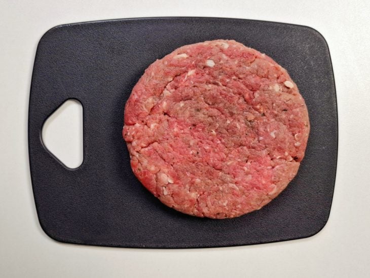 Carne moída moldada em formato de hambúrguer.