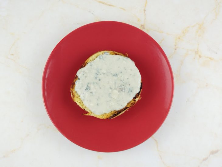 Uma fatia de pão coberta com o molho de gorgonzola.
