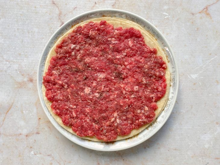 Porção de carne acomodada sobre o Rap10 e temperada com sal e pimenta-do-reino.
