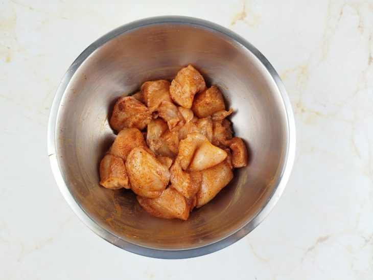 Peito de frango cortado e temperado numa tigela.