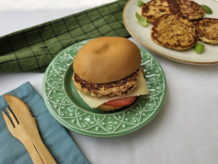 Um prato contendo um sanduíche com hambúrguer de frango fit com aveia.