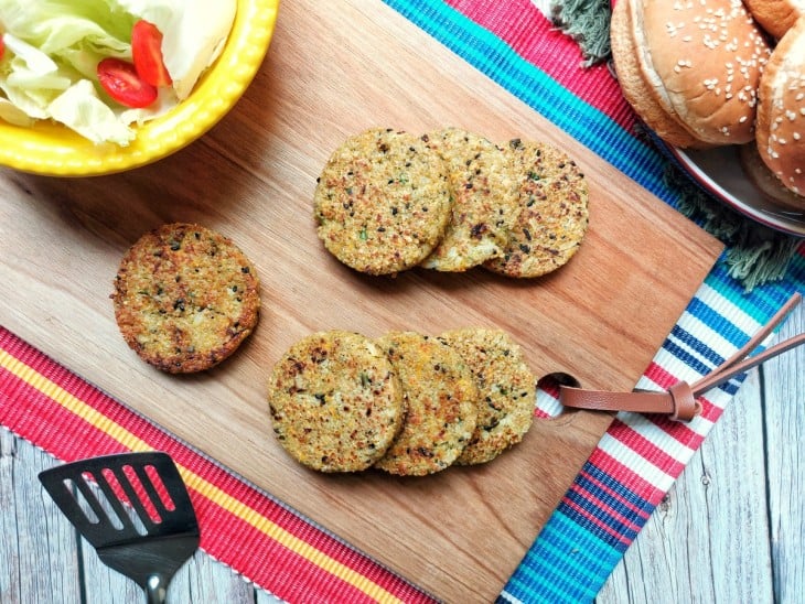 Uma tábua com vários hambúrgueres de quinoa.