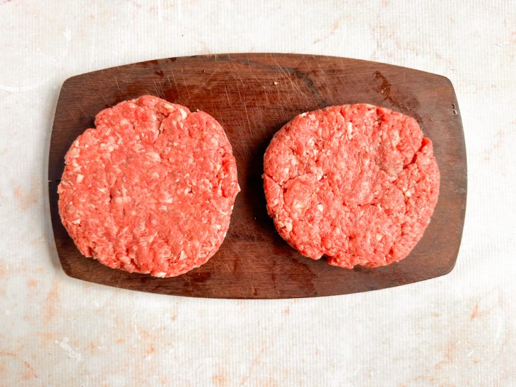 Hambúrgueres moldados em formato de disco com cerca de 1,5 cm de espessura.