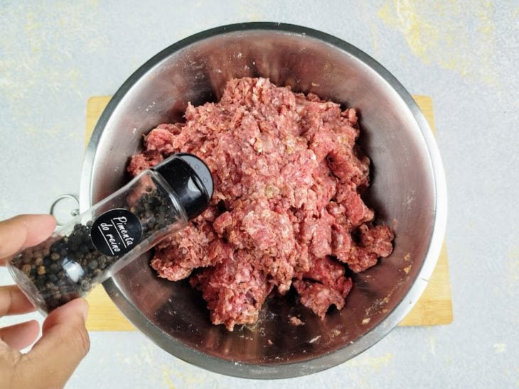 Carne com temperos em uma tigela de inox redonda.