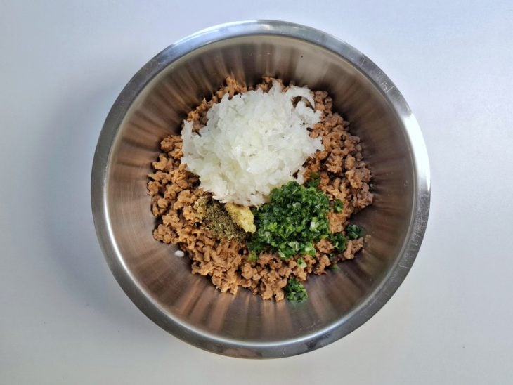 Uma tigela com proteína de soja, shoyu, cebola, alho e temperos.