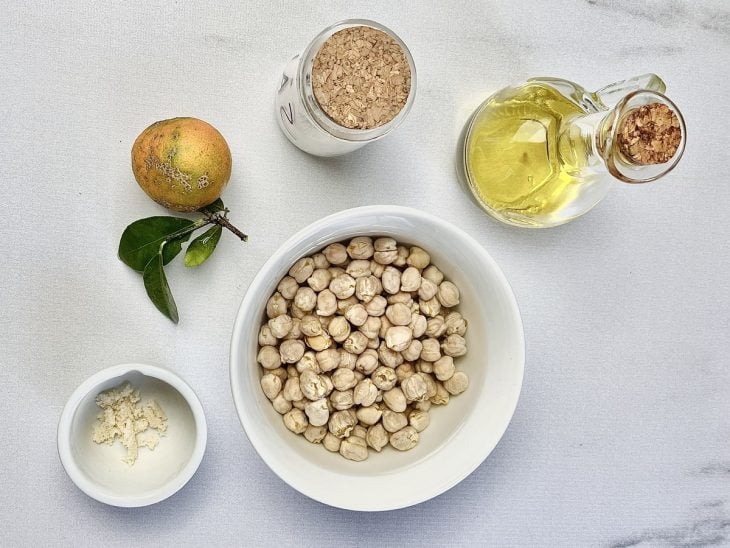 Ingredientes para a receita de homus sem tahine reunidos em uma bancada.
