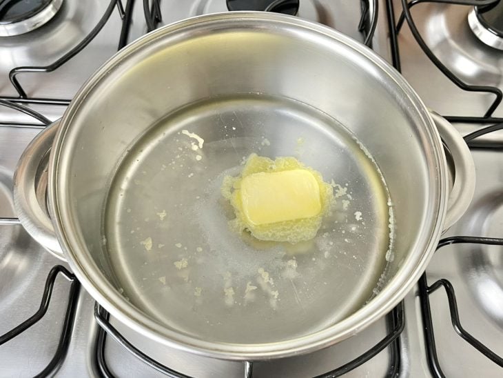Uma panela ao fogo com manteiga e sal.