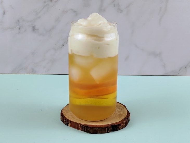 Copo com chá e espuma de gengibre.