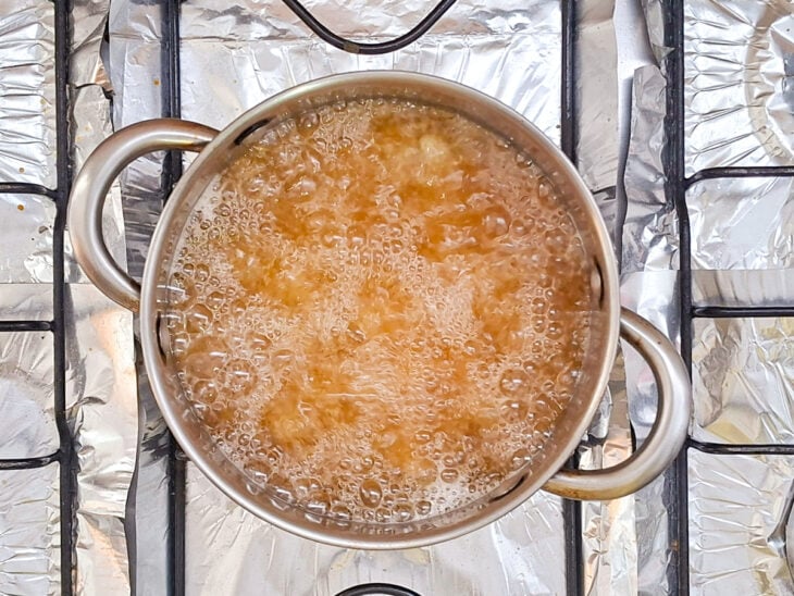 Iscas de frango fritando em óleo quente.