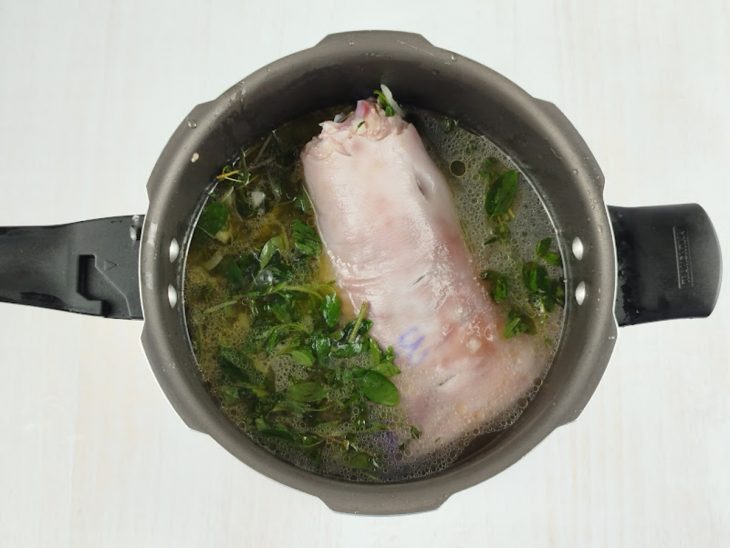 Joelho e temperos na panela de pressão.