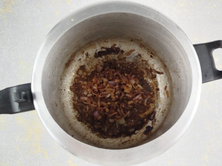 Cebola sendo refogada na mesma panela aproveitando o fundo da carne.