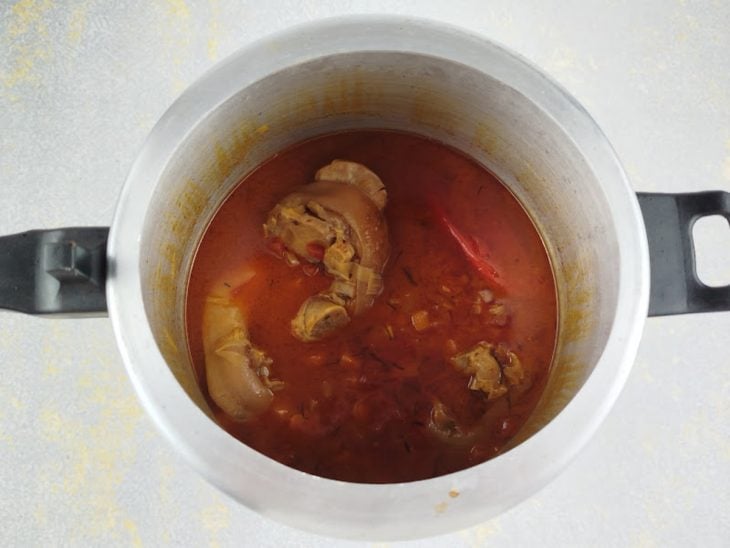 Carne sendo verificada e perfurada após abertura da panela.