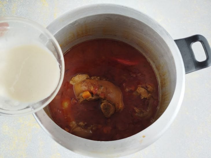 Mistura de farinha com água sendo adicionada ao caldo para engrossar.