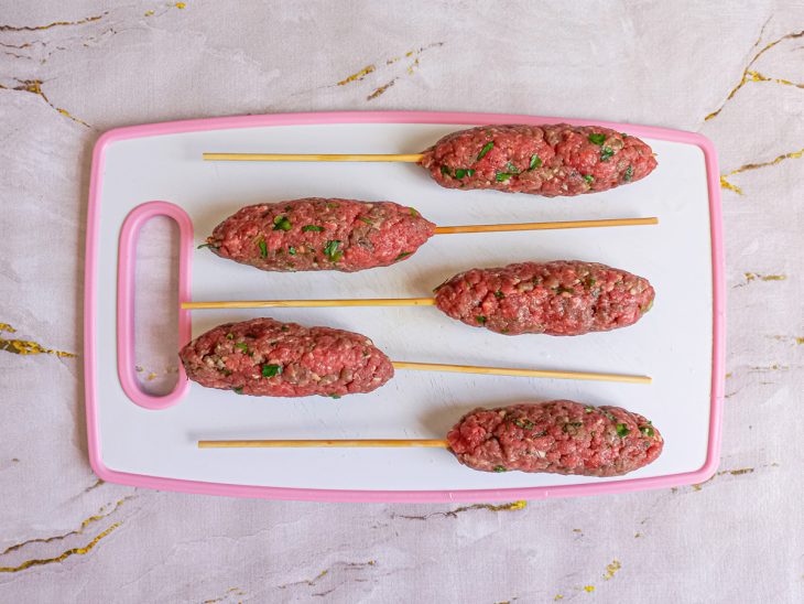 Espetos de kafta sobre uma tábua.