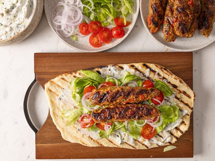 Uma tábua com kebab sendo recheado.