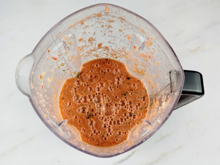 Ervas e temperos adicionados no liquidificador para serem batidos.