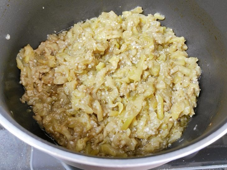 Berinjela ralada com azeite em uma panela.