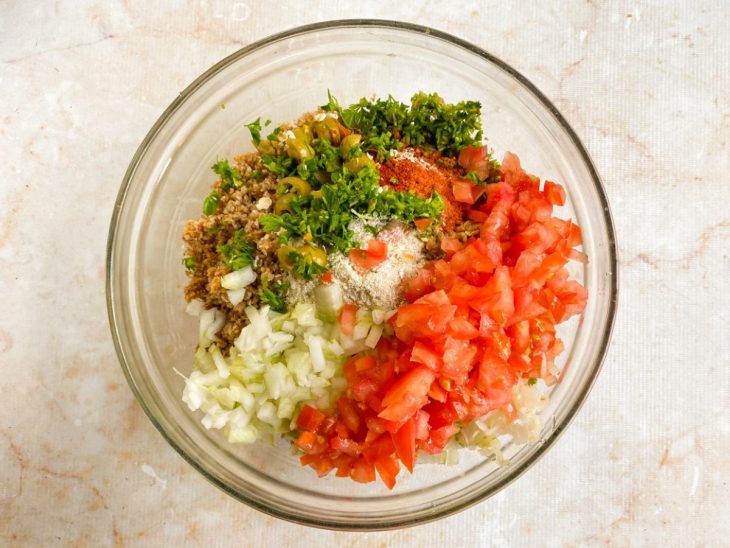 Trigo escorrido e ingredientes adicionados num recipiente.