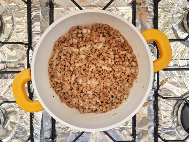 Uma panela com PTS, azeite, cebola e alho.