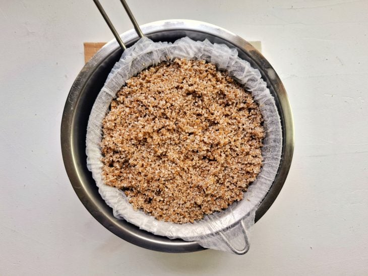 Trigo para kibe sobre um pano e peneira, sendo coado.