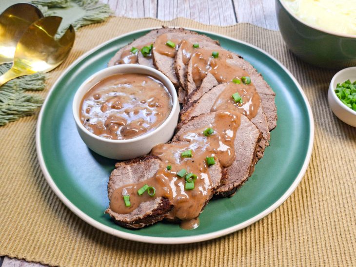 Lagarto pronto, fatias servidas com molho.