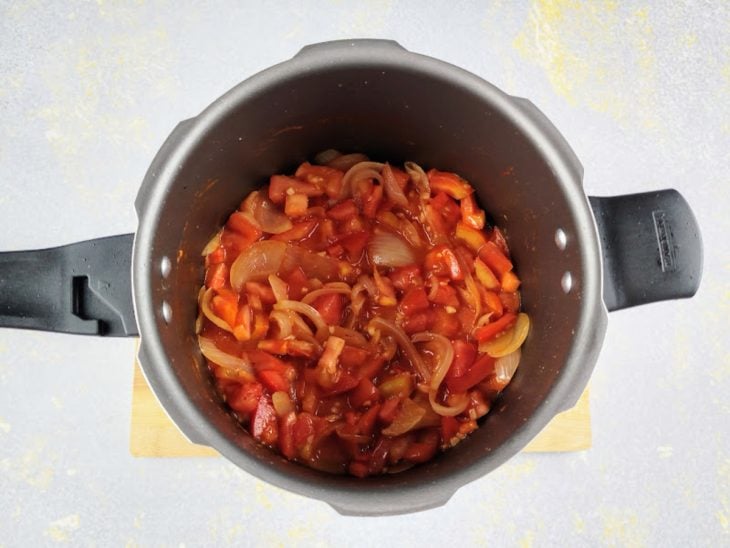 Extrato de tomate e tomate picado adicionados na panela de pressão.