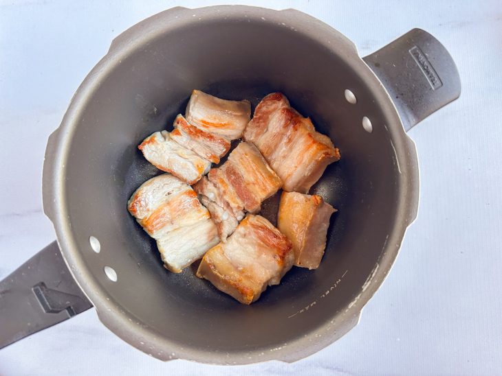 Na panela, os pedaços de panceta selados.