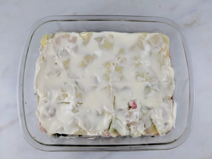 Fatias de queijo mussarela e camada de requeijão adicionadas a travessa.