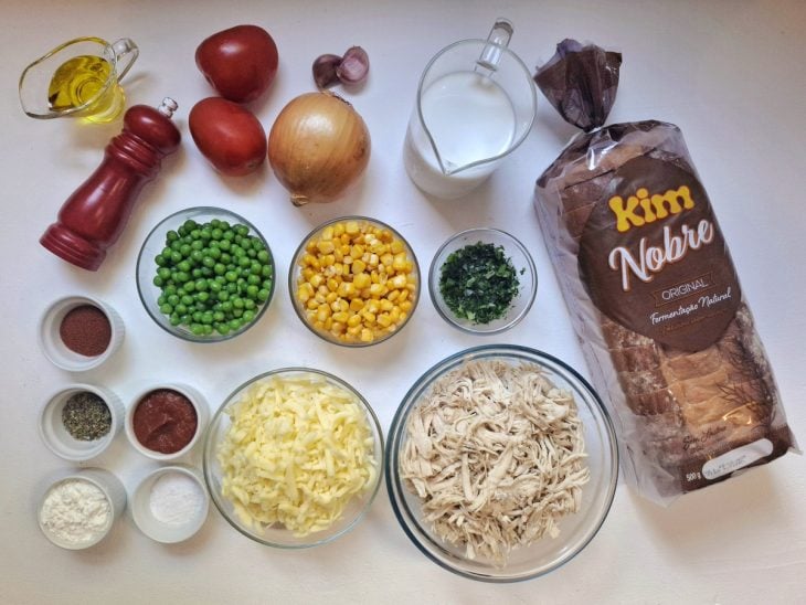 Ingredientes para preparar o lanche de forno com frango em uma bancada.