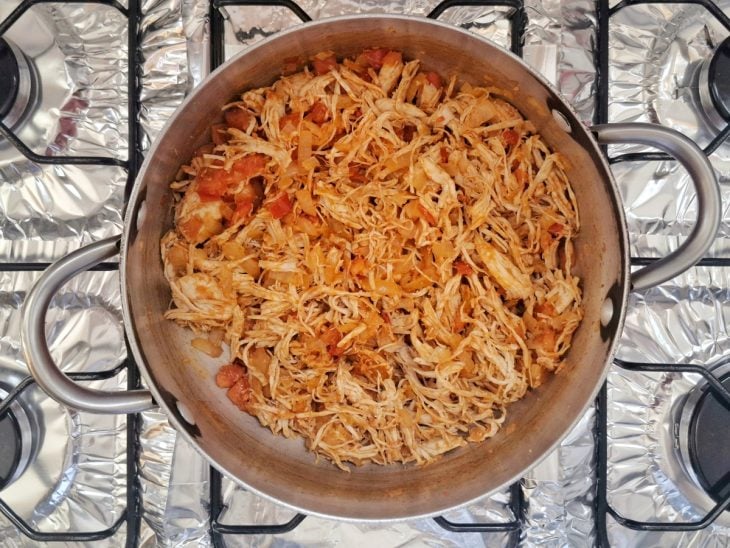 Panela com tomate refogado e frango.