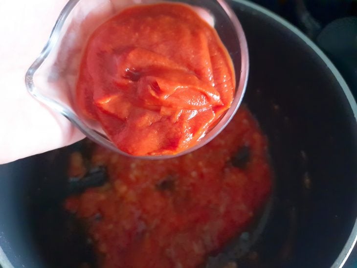 Extrato de tomate sendo adicionado à panela.