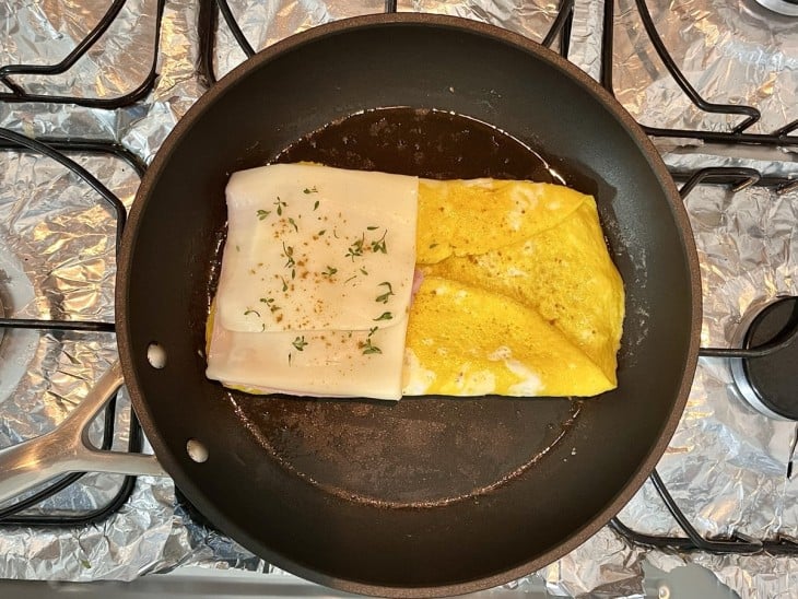 Uma frigideira com a omelete e queijo.