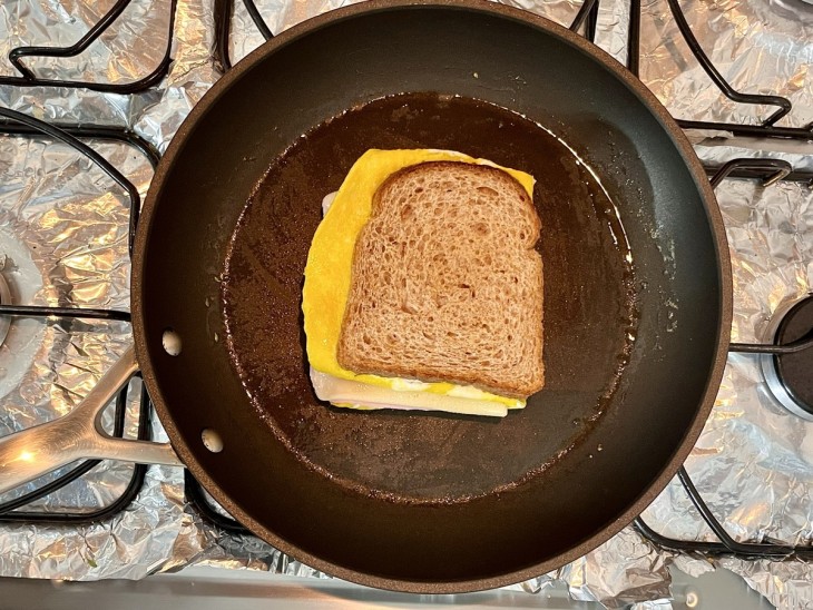 Uma frigideira com o sanduíche.