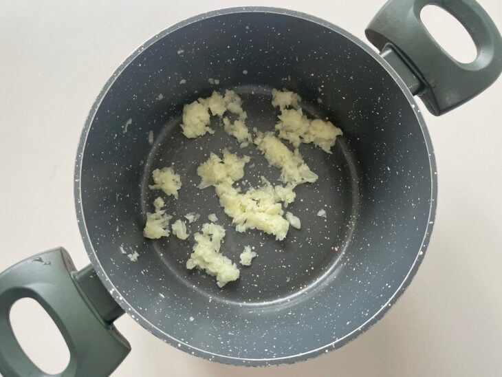 Alho e cebola refogando na panela.