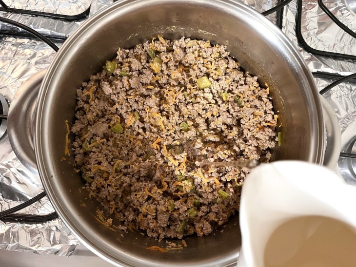 Uma panela com carne moída e vinho branco.