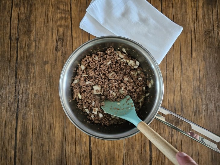 Uma panela contendo carne moída refogada com cebola e alho.