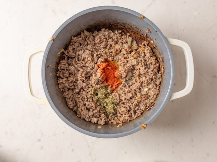 Uma panela com a carne moída e os temperos.