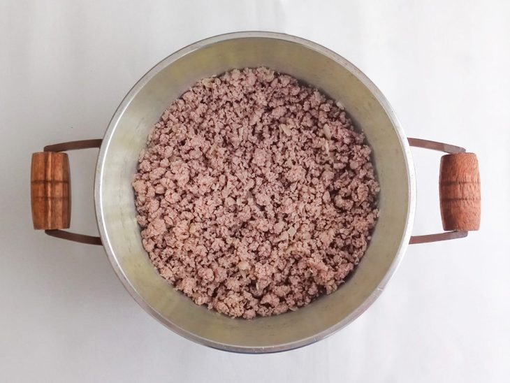 Carne moída adicionada a panela com alho e cebola.