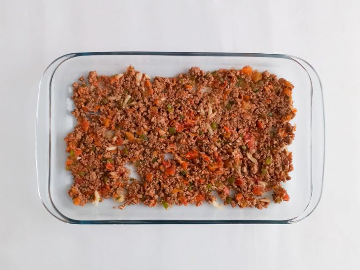 Camada de carne moída em um refratário de vidro.